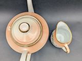 a tea pot and a cup sitting on a table