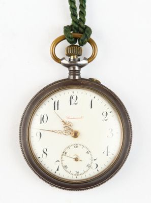 a pocket watch hanging from a rope on a white wall