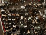 many bottles of wine that are stacked on a rack