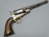 a close up of a revolver with a wooden handle on a gray surface