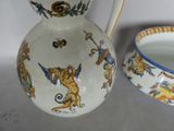 a pitcher and bowl sitting on a table next to each other