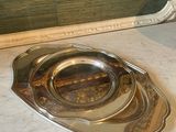 a silver plate that is on the floor next to a mirror