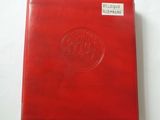 a red leather album with a medallion on the cover