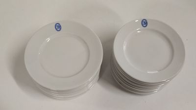 several white plates are stacked on top of each other on a table