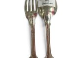 pair of silver plated spoons and fork on a white surface