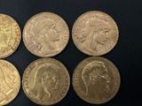 six different types of gold coins on a black surface