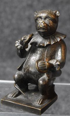 a bronze statue of a teddy bear holding a guitar