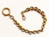 gros plan d'un bracelet en chaîne en or sur fond blanc