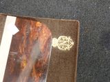 a brown leather wallet with a gold buckle on it