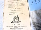 un vieux livre posé sur une table, avec un mot accroché dessus