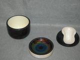 three bowls and a cup sitting on a table
