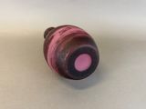 a pink and black object sitting on a white surface