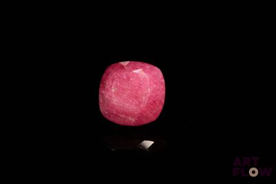 une pomme rose posée sur une surface noire