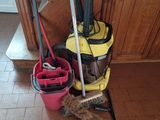 a mop, bucket, broom, and mop holder on the floor