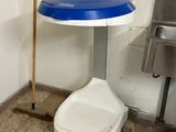 des toilettes avec un siège bleu à côté d'une poubelle