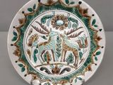 une assiette sur laquelle est représenté un cerf et sur laquelle se trouve un cerf