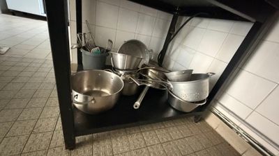 de nombreuses casseroles et poêles sur l'étagère de la cuisine