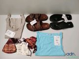 several pairs of sandals, a purse, a t - shirt, and a pair of sandals are on a table