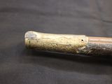 a wooden stick with a metal handle on a black surface