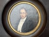 portrait of a man in a tuxedo in a gold frame