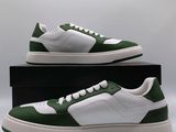 men ' s green and white sneakers with white soles on a black box