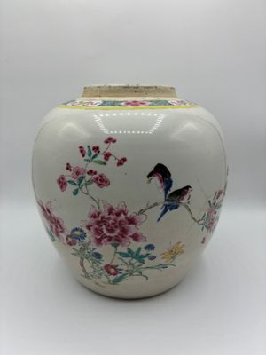 un vase blanc sur lequel sont peints un oiseau et des fleurs