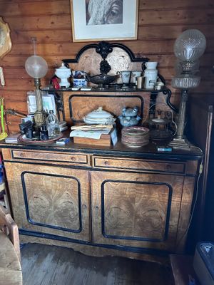 a large wooden cabinet with many items on top of it