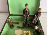 three figurines of people in a green box