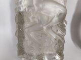 a glass vase with a bird on it on a table