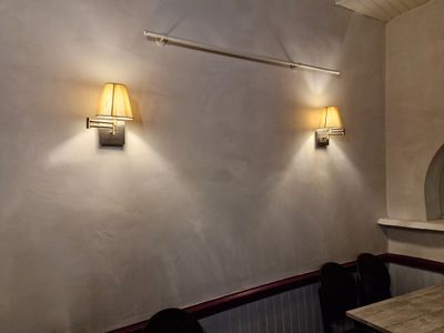 deux lampes accrochées au mur au-dessus d'une table dans un restaurant