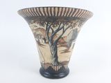 a vase with a painting on it sitting on a table