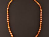 un collier de perles orange sur fond noir