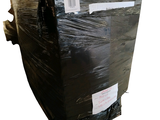 a large black box wrapped in plastic and sitting on a white surface