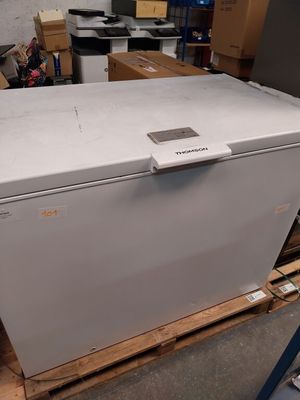 a white chest freezer sitting on a pallet in a warehouse