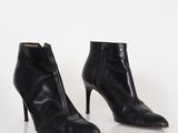 a pair of black leather ankle boots on a white surface
