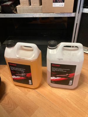 deux gallons de liquide posés sur une table en bois