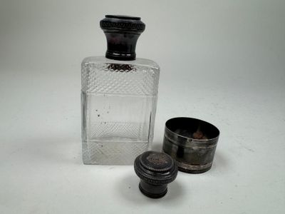 a small glass bottle and a small metal cup
