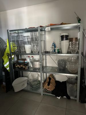 a man standing in front of a shelf filled with dishes