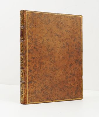 un vieux livre à la couverture brune posé sur une surface blanche