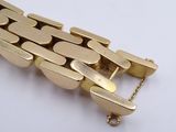 an image of a close up of a gold bracelet on a white surface