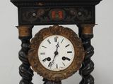 une horloge posée sur un support sur une table