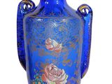 un vase bleu orné d'un motif de roses