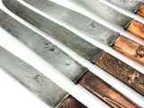 five knives that are sitting on a white surface