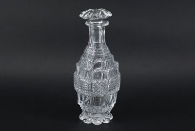 a clear glass vase on a black surface with a black background