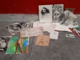 a pile of drawings on the ground next to a red wall