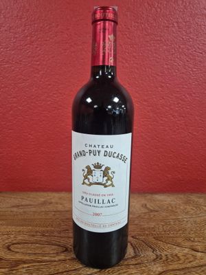 la bouteille de vin rouge est posée sur une table en bois