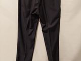 a black pants hanging on a hanger against a white wall