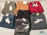 a lot of different colored jeans on a table