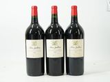trois bouteilles de vin rouge posées sur une table blanche