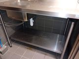 a stainless steel sink in the corner of a kitchen